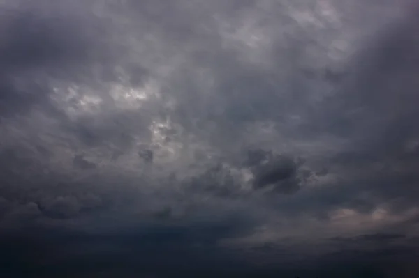 Mörka regnmoln under solnedgången. Dramatisk himmel under solnedgången. Mörka Storm moln med svarta och vita höjdpunkter. — Stockfoto