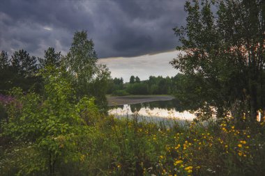 Göl yaz manzara tarafından ormanda gün batımı.