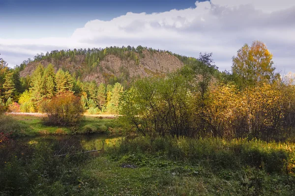 Rio de outono com árvores refletoras contra o pano de fundo de florestas e montanhas . — Fotografia de Stock