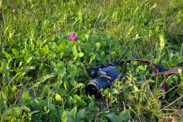 Un appareil photo reflex numérique noir se trouve sur l'herbe gros plan . — Photo