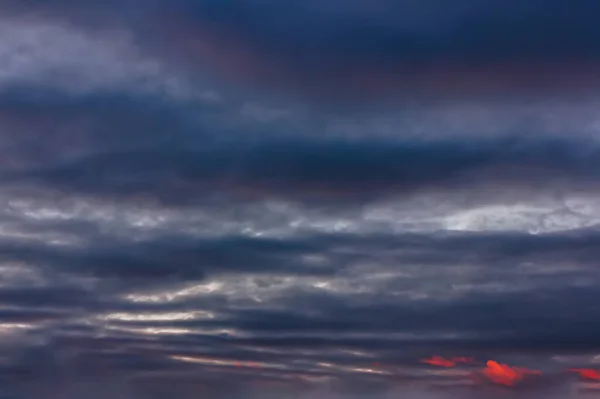 De hemel bij zonsondergang. Cumulus wolken verlicht door de stralen van de ondergaande zon. — Stockfoto