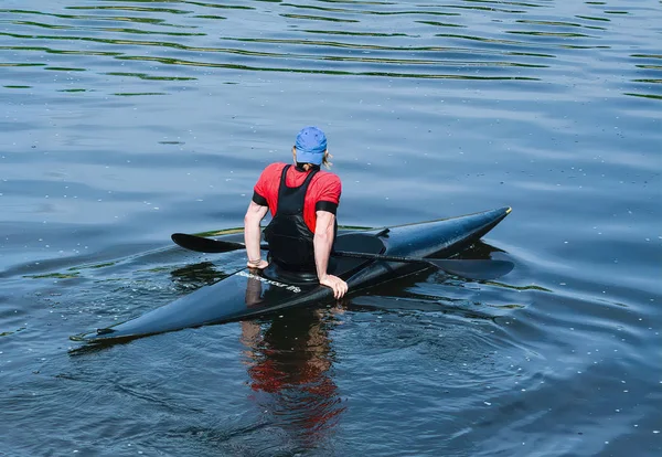 L'athlète flotte sur la rivière en kayak avec le flux de la pagaie . — Photo
