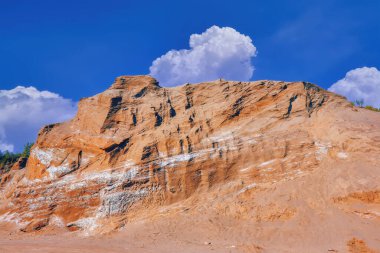 Kum tepeleri mavi gökyüzüne ve beyaz bulutlara karşı. Yaz manzarası.