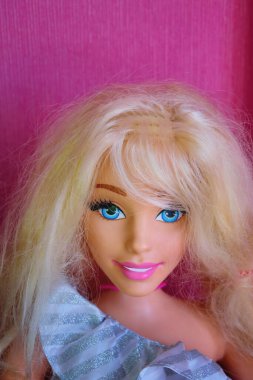 Pembe arka planda bir Barbie bebeğin yakın plan portresi..