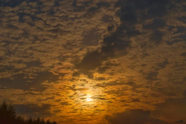 Akşam Gökyüzü Resimli Bulutlarda Batan Güneşin Işınlarıyla Aydınlatılıyor — Stok fotoğraf