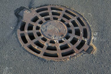Parktaki kanalizasyon sisteminin dökme demir rögar kapağı. Yakın plan..