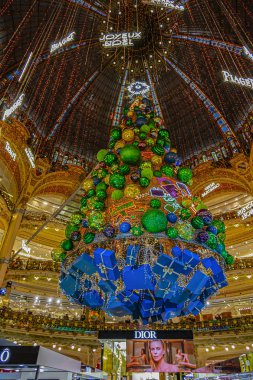 PARIS, FRANCE DECEMBER 31, 2018: Christmas tree in Galeries Lafayette in Paris on Boulevard Haussmann. Galeries Lafayette is one of most popular, chic and distinguished shopping centers in Paris. clipart