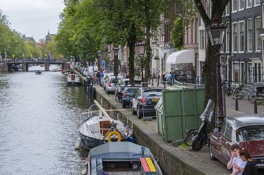 Amsterdam, Hollanda - 21 Ağustos 2019: Tipik Hollanda evleri ve tekneleriyle Lijnbaansgracht kanalının güzel manzarası. Amsterdam 'da 100 kilometreden fazla kanal ve 1500 köprü var..