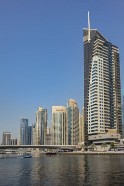 DUBAI, UAE - JULY 14, 2018: Modern skyscrapers and embankment in famous Dubai Marina. Marina - artificial canal city, carved along a 3 km stretch of Persian Gulf shoreline.