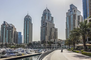 DUBAI, UAE - JULY 14, 2018: Modern skyscrapers and embankment in famous Dubai Marina. Marina - artificial canal city, carved along a 3 km stretch of Persian Gulf shoreline.