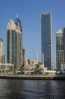 DUBAI, UAE - JULY 14, 2018: Modern skyscrapers and embankment in famous Dubai Marina. Marina - artificial canal city, carved along a 3 km stretch of Persian Gulf shoreline.