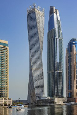 DUBAI, UAE - JULY 14, 2018: Modern skyscrapers and embankment in famous Dubai Marina. Marina - artificial canal city, carved along a 3 km stretch of Persian Gulf shoreline.