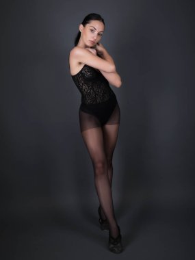 Stüdyoda poz veren siyah elbiseli bir balerin..