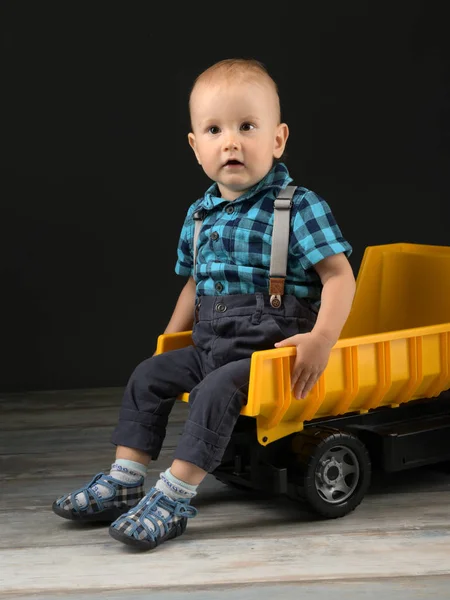 小さな男の子は大きなおもちゃのトラックで遊ぶ — ストック写真