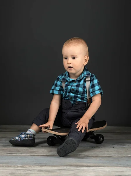 Malý Chlapec Sedí Skateboardu Studiu — Stock fotografie