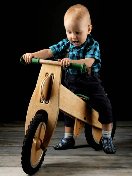 小男孩在工作室里玩玩具木摩托车 — 图库照片