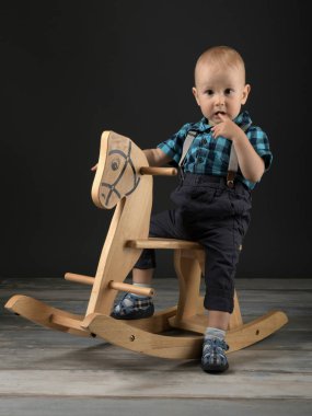 Tatlı küçük çocuk evde tahta at, çocukluk oyunları oynamak