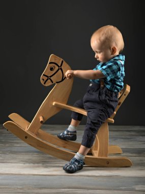 Tatlı küçük çocuk evde tahta at, çocukluk oyunları oynamak