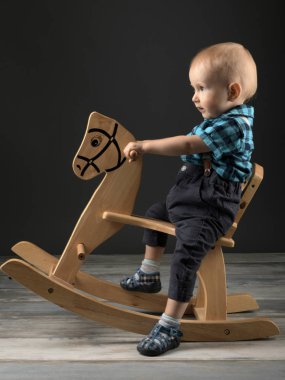 Tatlı küçük çocuk evde tahta at, çocukluk oyunları oynamak