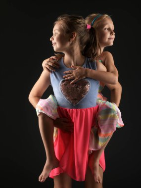 İki sevimli küçük kız kardeşi araya sokulmuş