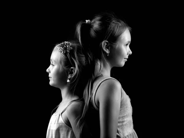 两个可爱的小妹妹挤成一团 白纸黑字地挤在一起 — 图库照片