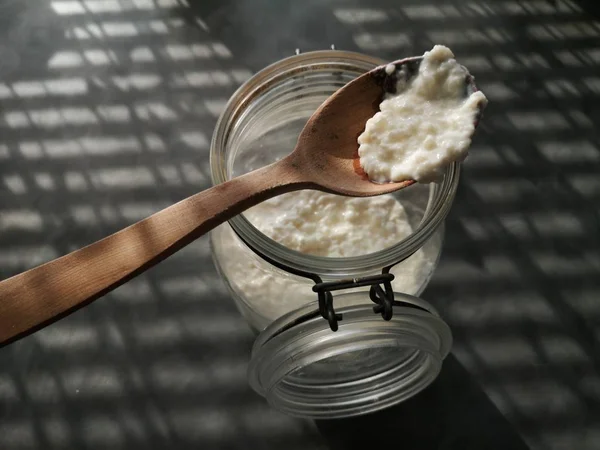 木のスプーン ガラス容器に牛乳をケフィアのオーガニック プロバイオティック 乳ケフィア粒 チベット キノコします — ストック写真