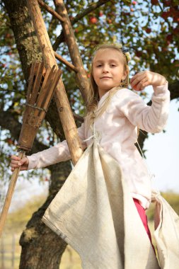 Young girl picking red apples in an orchard