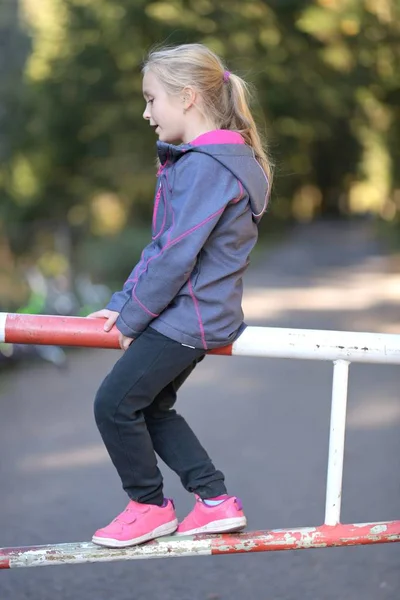 Mädchen Sitzt Auf Der Absperrung — Stockfoto