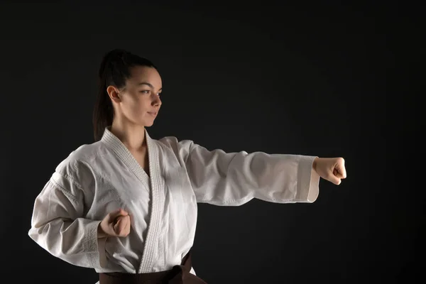 Young woman dressed in traditional kimono practicing her karate moves