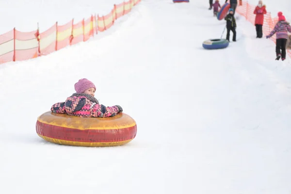 雪の公園で女の子が丘の上で寝ていて — ストック写真