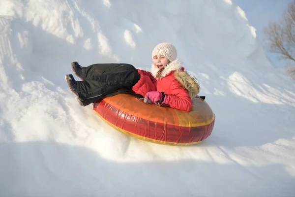 雪の公園で女の子が丘の上で寝ていて — ストック写真