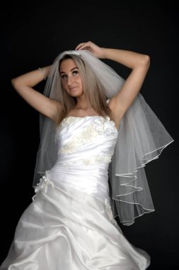 Siyah arka planda beyaz elbiseli güzel sarışın gelin.