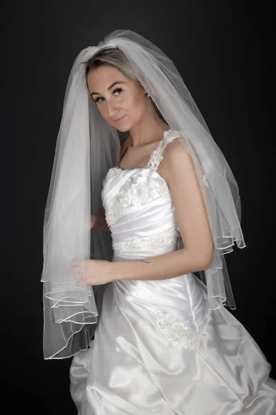 漂亮的金发碧眼的新娘 身穿黑色背景的白色礼服 — 图库照片