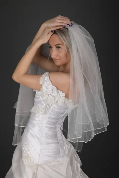 漂亮的金发碧眼的新娘 身穿黑色背景的白色礼服 — 图库照片