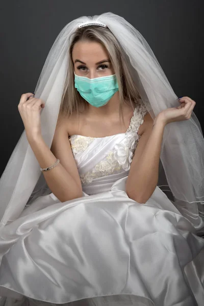 美しいですブロンド花嫁で白いドレスでA医療用マスク — ストック写真