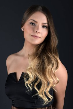 Temiz ciltli, doğal makyajlı ve gri arka planda beyaz dişli güzel bir kadın. 
