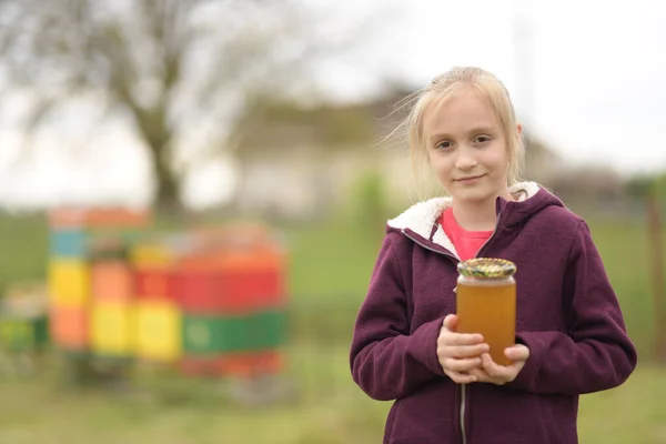 小さな女の子の養蜂家は巣箱で働きます — ストック写真
