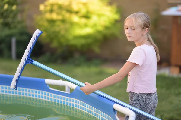 年轻姑娘在清理游泳池 — 图库照片