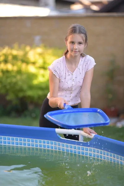 漂亮的小女孩在清理游泳池 — 图库照片