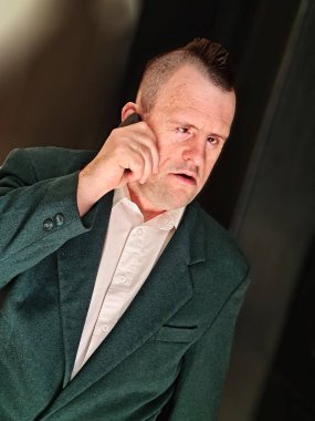 Down sendromlu bir adam telefonda konuşuyor.