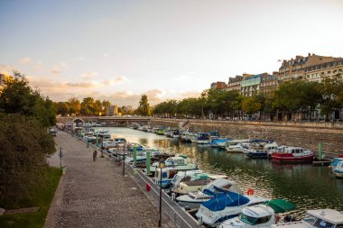Paris, Fransa - 10 Ekim 2013: Köprü Paris'te Seine Nehri ile Fransa gün batımında. Tekneler arka planda