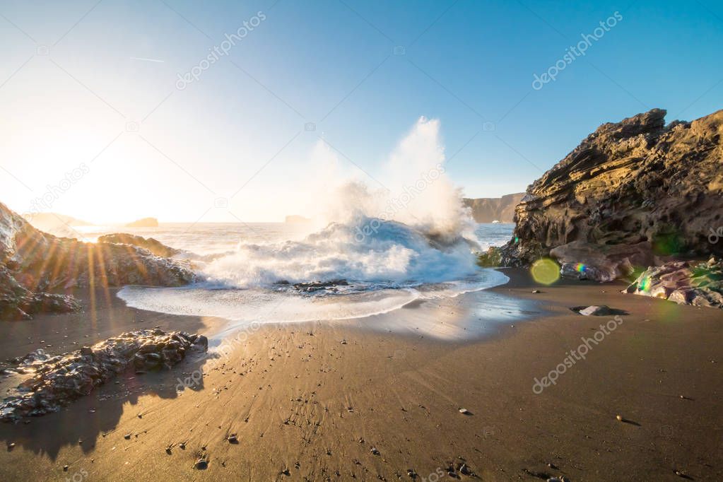 Beach in Iceland on sunny day with big waves