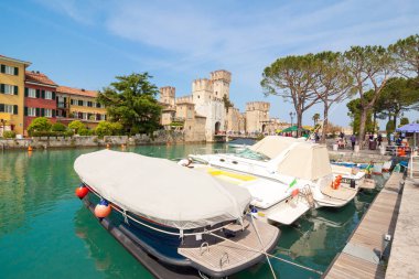 Sirmione, İtalya - 16 Mayıs 2015: Sirmione şehir İtalya Garda Gölü yakınındaki Rocca Scaligera castle civarındaki turist. Tekneler arka planda