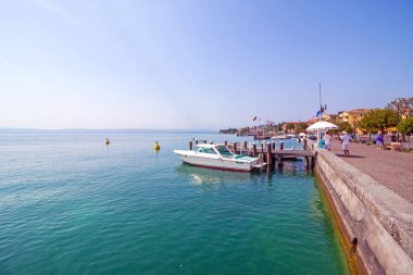 Sirmione, İtalya - 16 Mayıs 2015: Sirmione şehir İtalya Garda Gölü yakınındaki Rocca Scaligera castle civarındaki turist. Tekneler arka planda