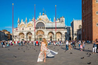 Venedik, Italya-25 Eylül 2016: beyaz elbise ile zarif kadın Venedik, Italya San Marco meydanında yürüyüş sahiptir