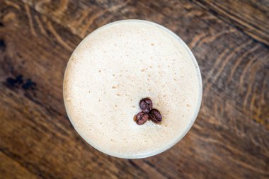 Bir fincan kahve, ahşap masa, üst manzara.