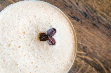 Bir fincan kahve, ahşap masa, üst manzara.