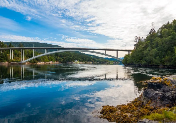 Bridge mirroring in water - sunny day near Alesund, Norway