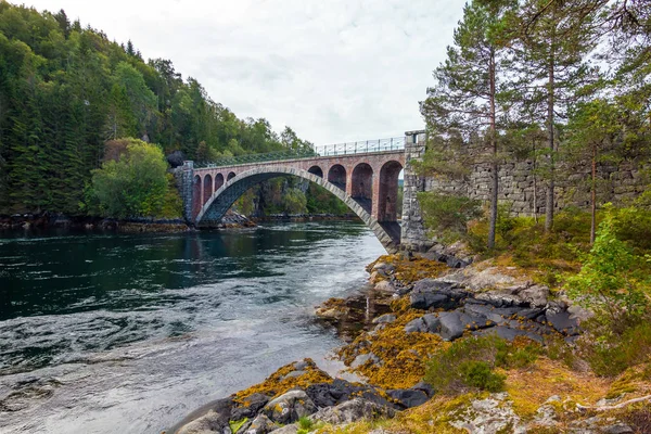 Bridge mirroring in water - sunny day near Alesund, Norway