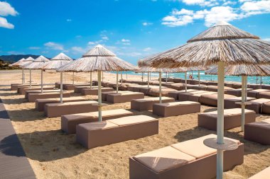 Villasimius plajında beyaz kumlu plajda şemsiyeli şezlonglar, Sardunya adası, İtalya